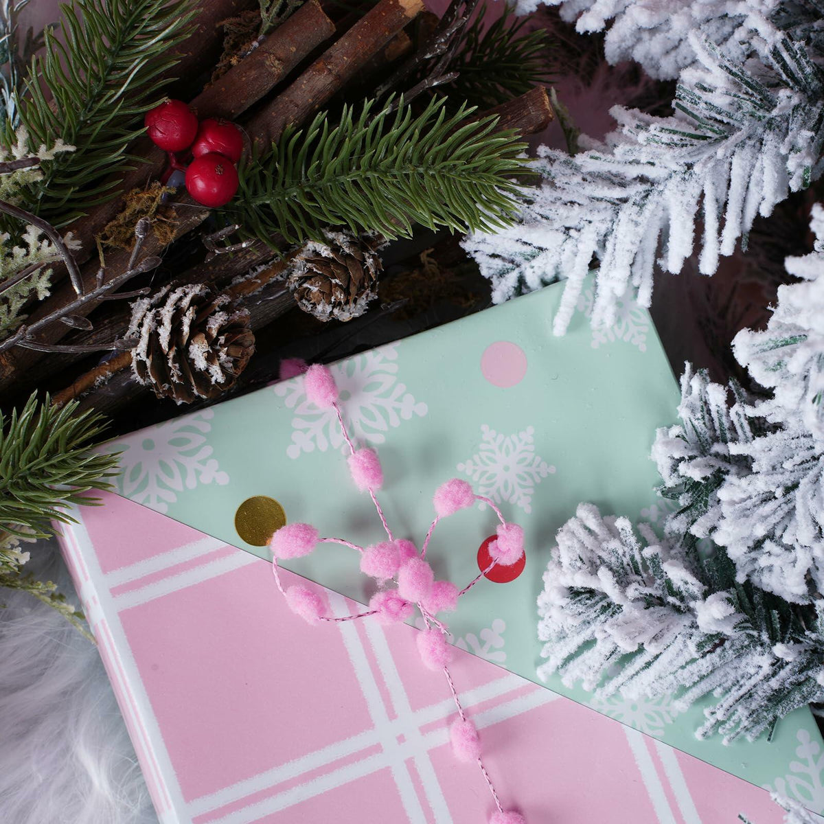Mint snowflake and pink plaid wrapping paper sheets with small pink pom trim