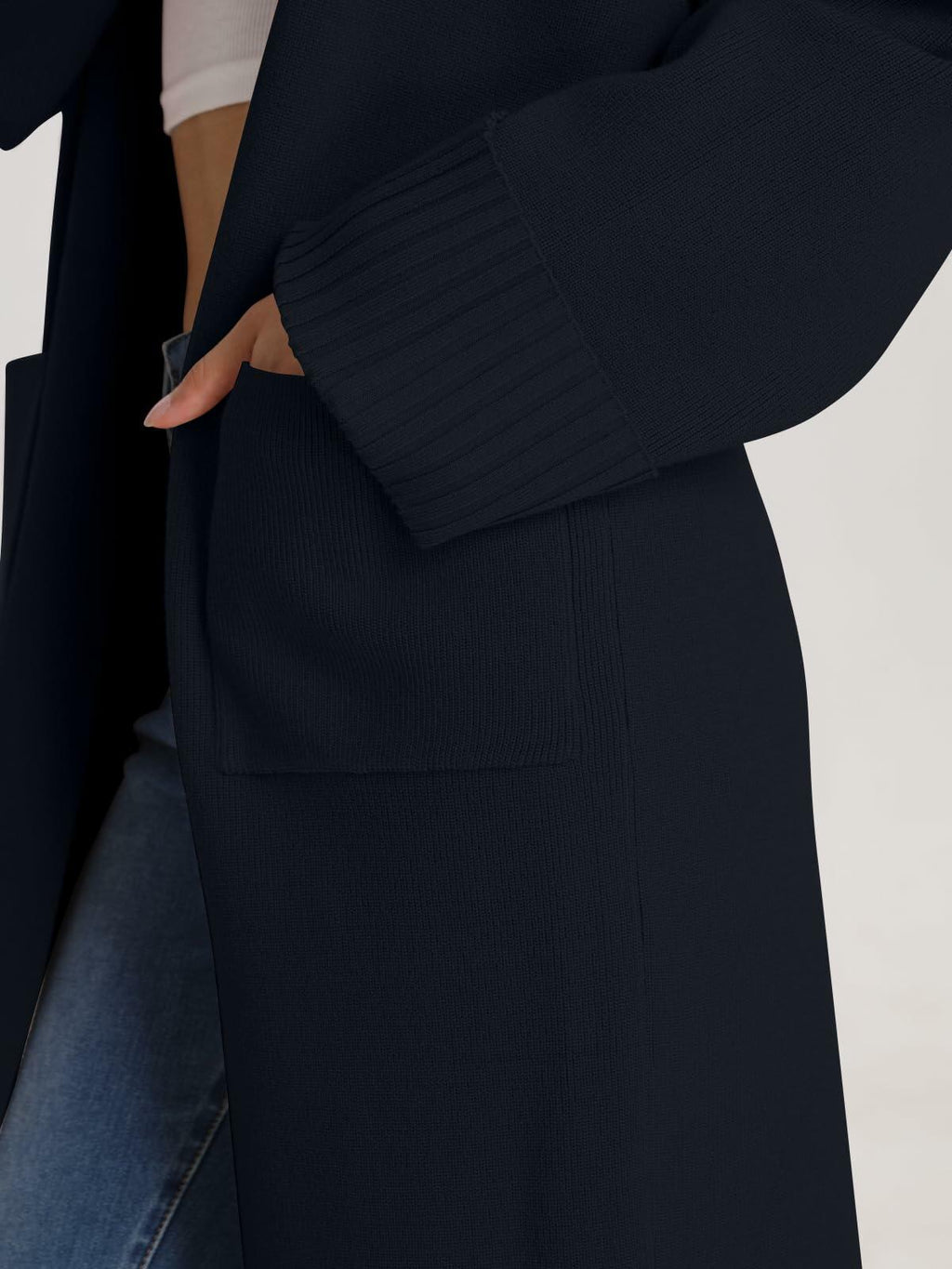 Black cardigan coatigan close-up: ribbed sleeve cuff and front patch pockets.