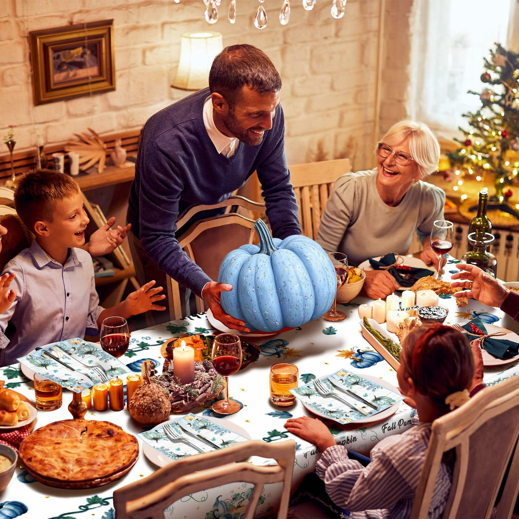 Blue fall pumpkin tablecloth covering dining table with matching patterned napkins