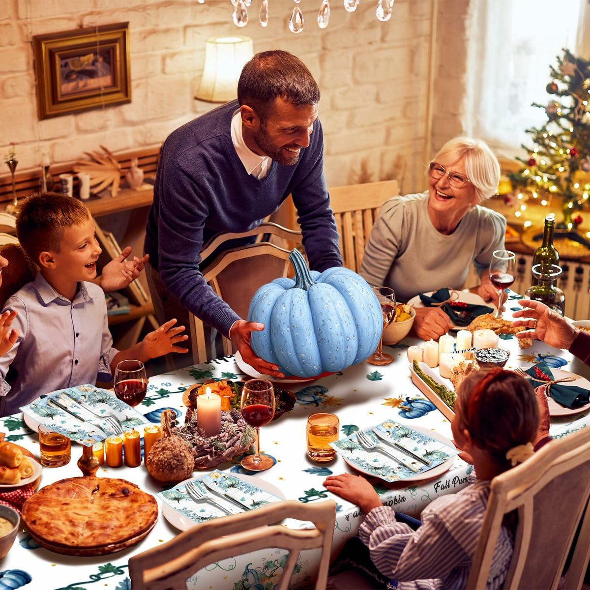 Blue fall pumpkin tablecloth covering dining table with matching patterned napkins