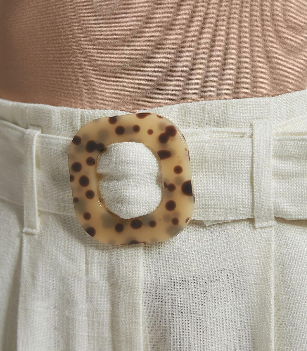 White linen pants front closure with tortoise-pattern belt buckle and button