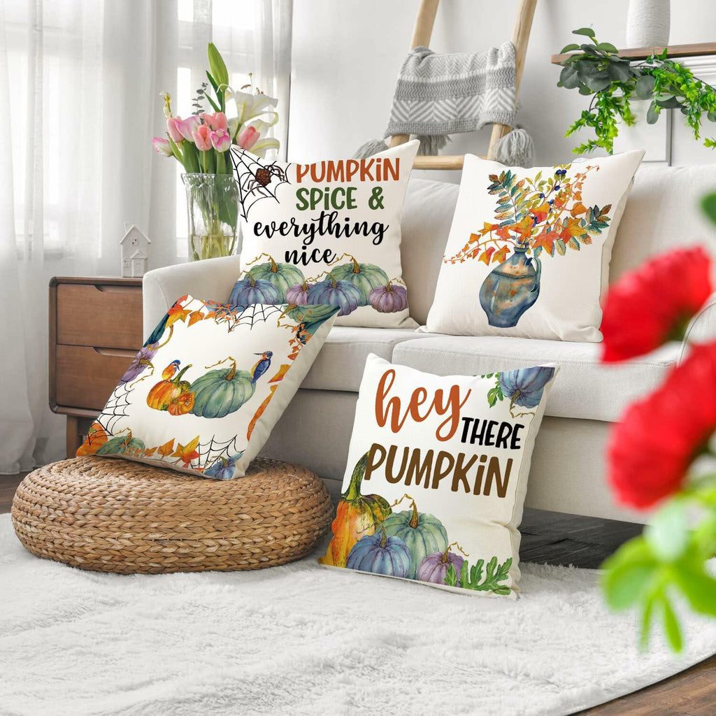Decorative fall pumpkin pillow covers on sofa, featuring 'Pumpkin Spice' and 'Hey There Pumpkin'