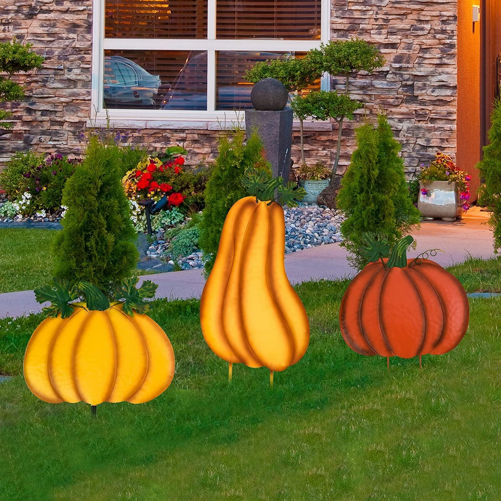 Stacked pumpkin yard stake decor with yellow and orange pumpkins and green leaf accents in grass