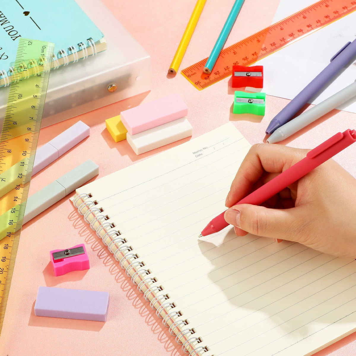 School writing supplies set with colored pens, rulers, erasers, and sticky notes on paper