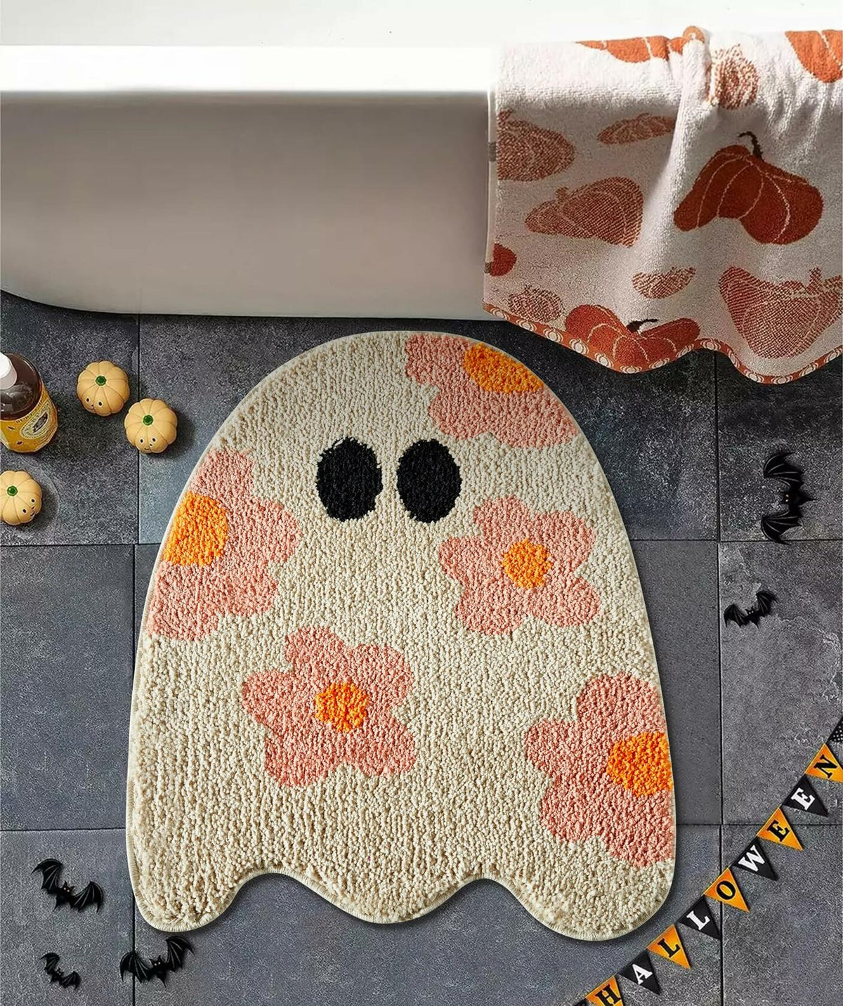 Beige ghost-shaped bath mat with black eyes and orange-pink floral pattern