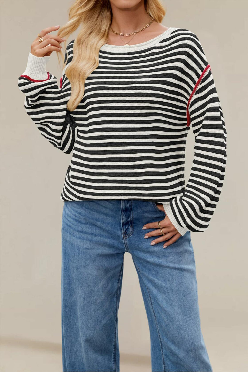 Black-and-white striped oversized boat-neck sweater with red-trim cuffs and ribbed hem