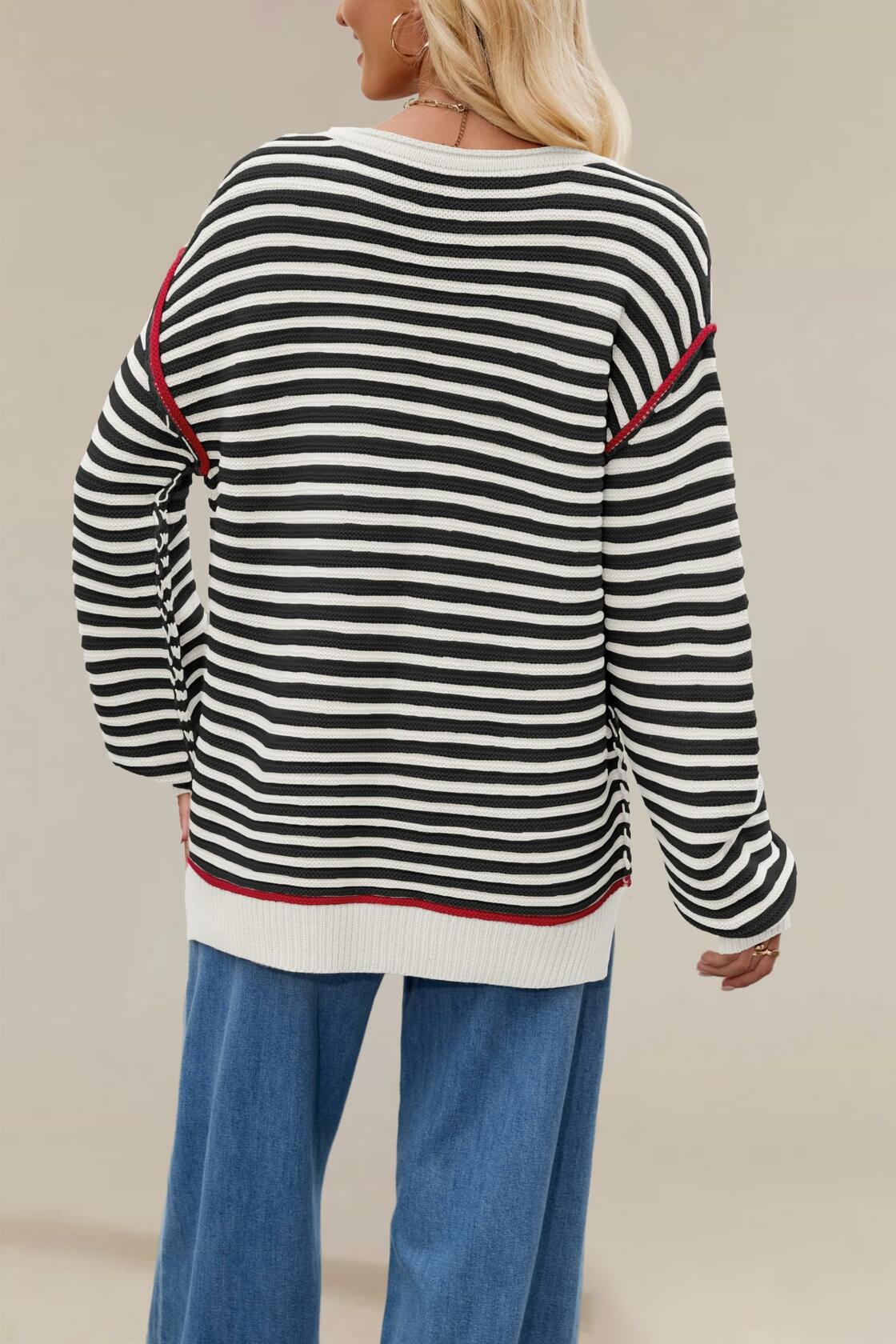 Black-and-white striped oversized boat-neck sweater shown from back, red-trim hem