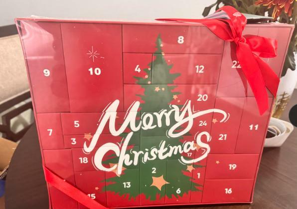 Christmas advent calendar box in red with numbered compartments and gift ribbon