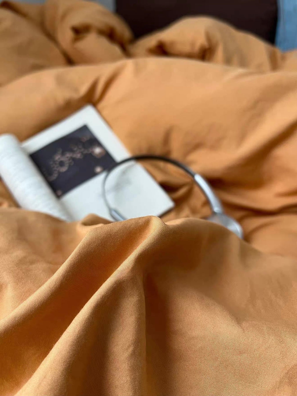 Close-up of orange duvet fabric texture with white-edged card and black cord