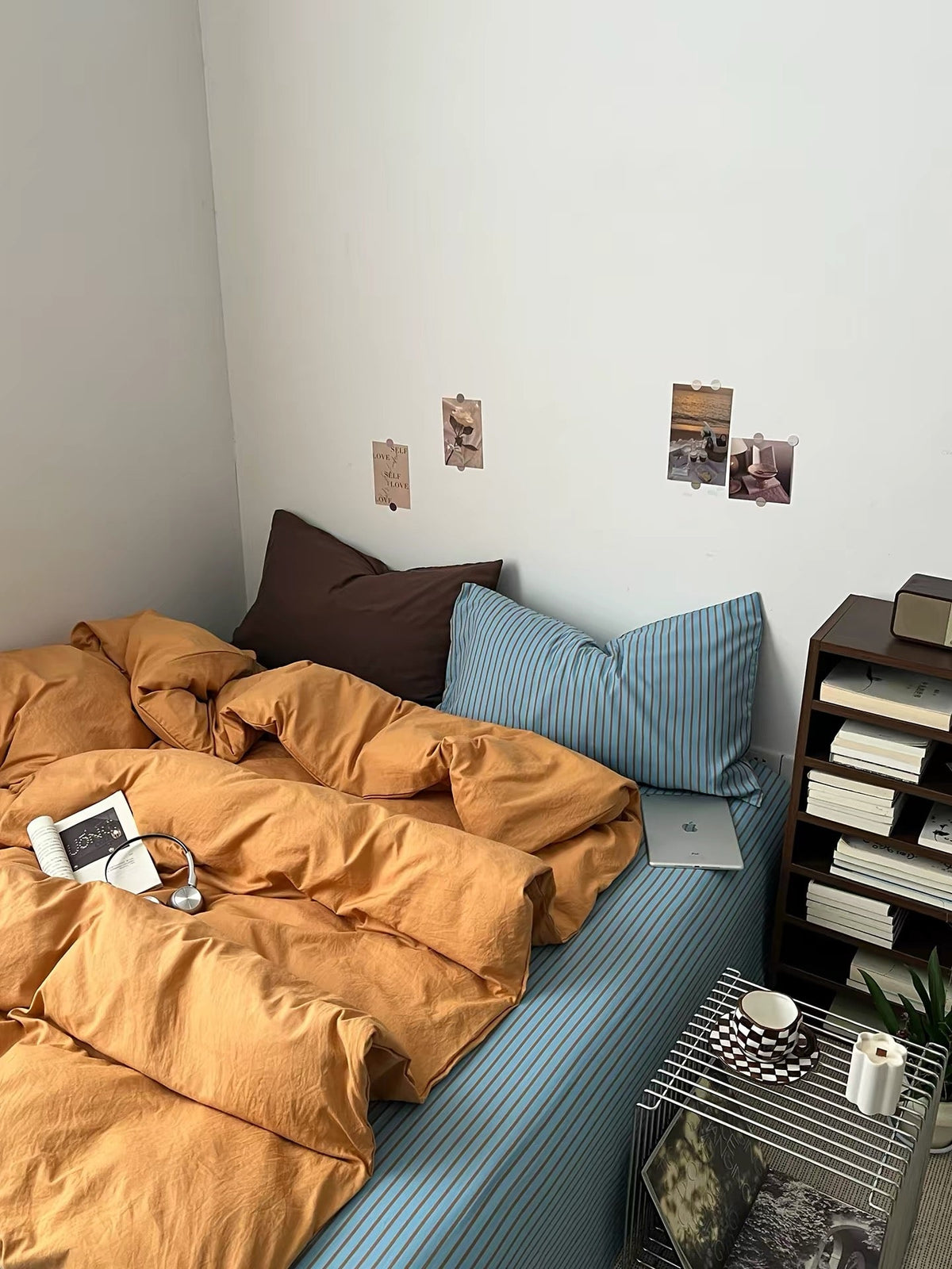 Orange bedding set featuring duvet cover, pillows, and a blue striped mattress base