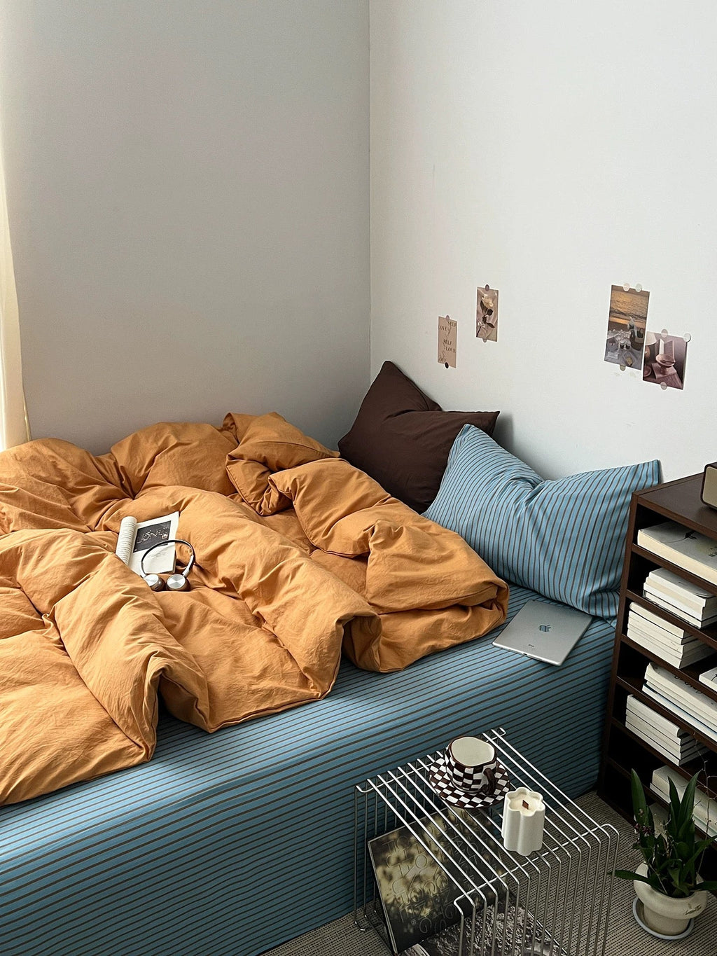Orange bedding set with duvet cover and pillows on a blue striped bed