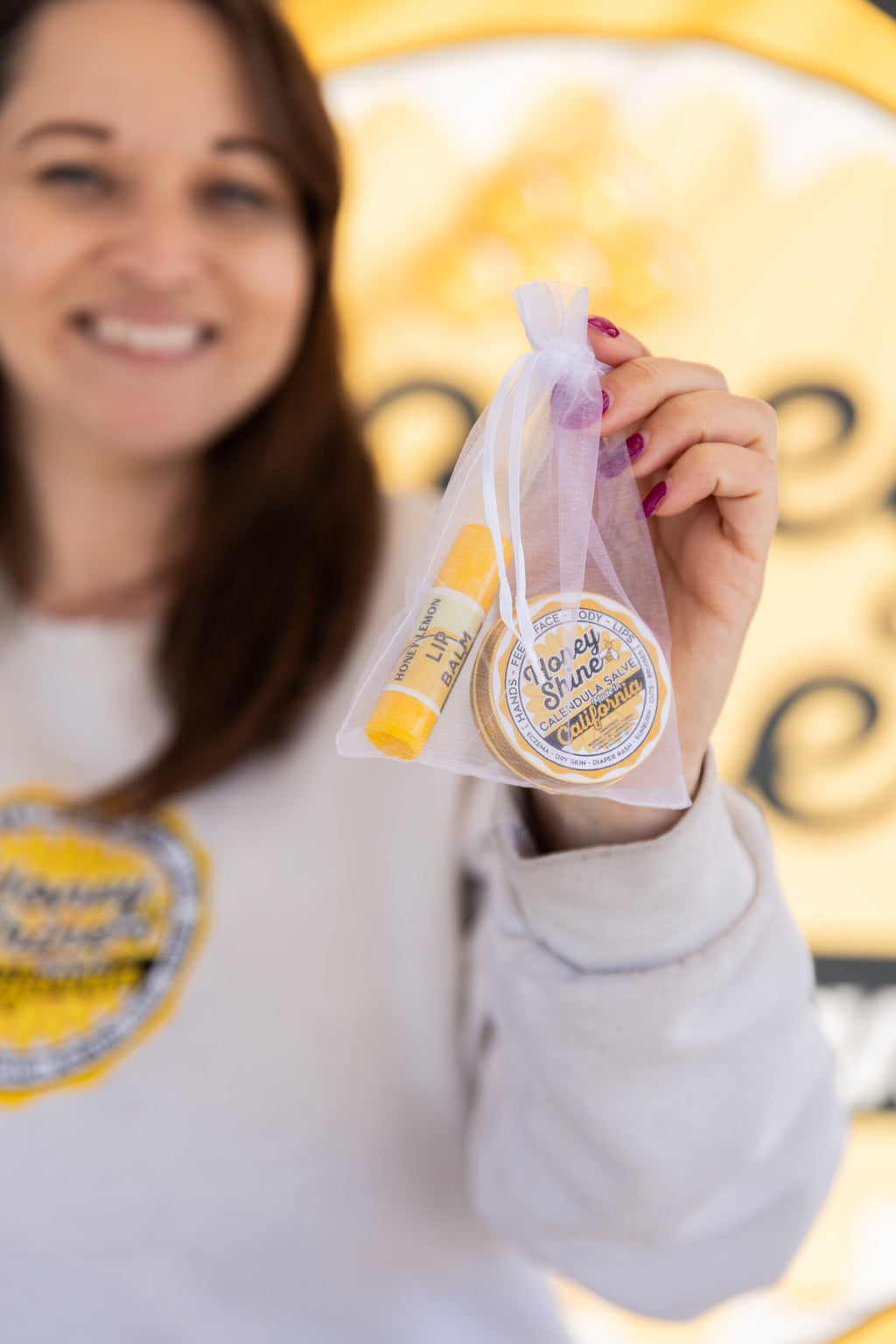 Sheer organza gift bag held with Honeyshine salve and Honey Lemon lip balm