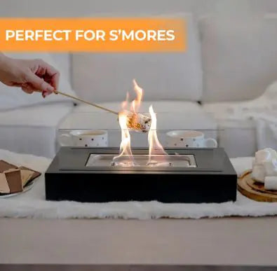 Black indoor mini alcohol fireplace with visible flame through glass burner tray