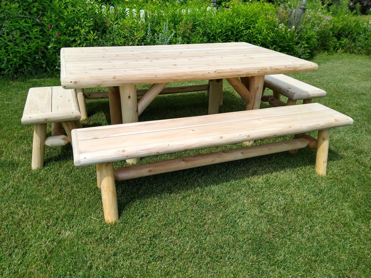 Outdoor picnic table with two benches, front view, light wood slatted seats on grass