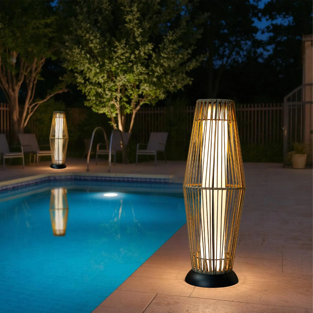 Outdoor solar wicker lantern floor lamps with glowing tops, standing on black base plates