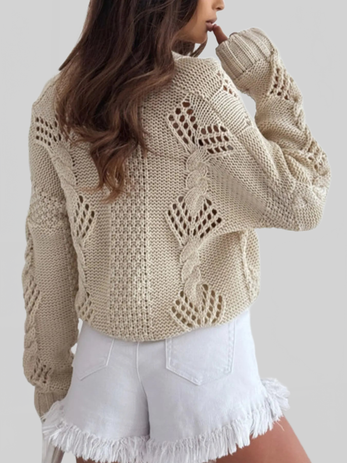 Beige cable-knit cardigan with V-neck button placket; ribbed cuffs and long sleeves