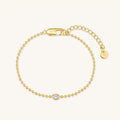 Gold-tone oval stone bracelet with beaded chain and oval centerpiece charm