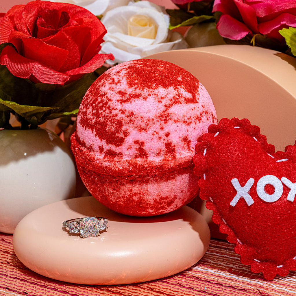 Red speckled bath bomb with small jeweled ring reveal