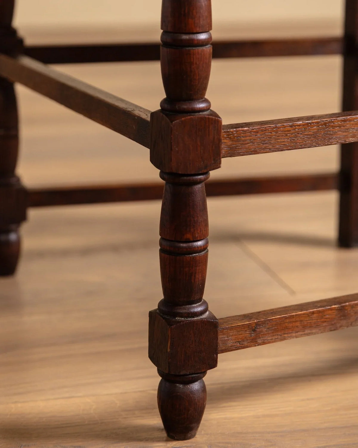 Close-up of turned wood leg and stretcher frame on an open-arm chair