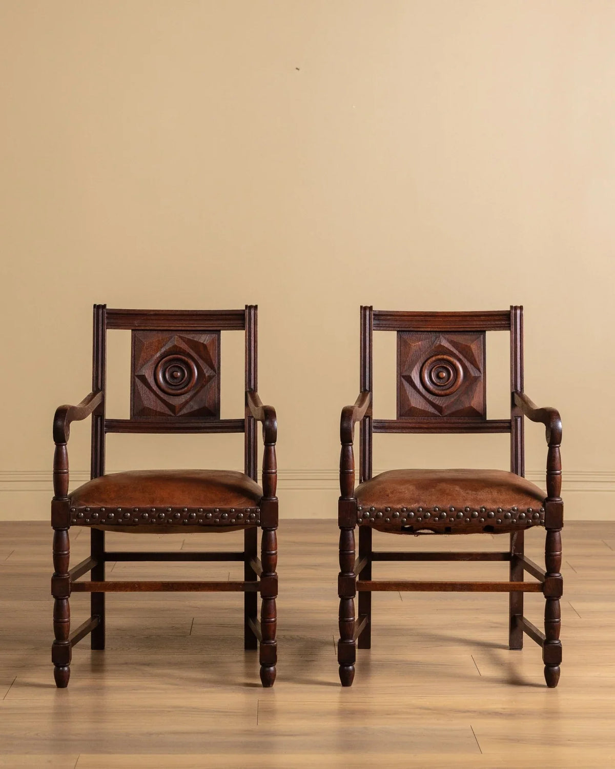 Two matching armchairs side view with diamond back panels and studded seat cushions