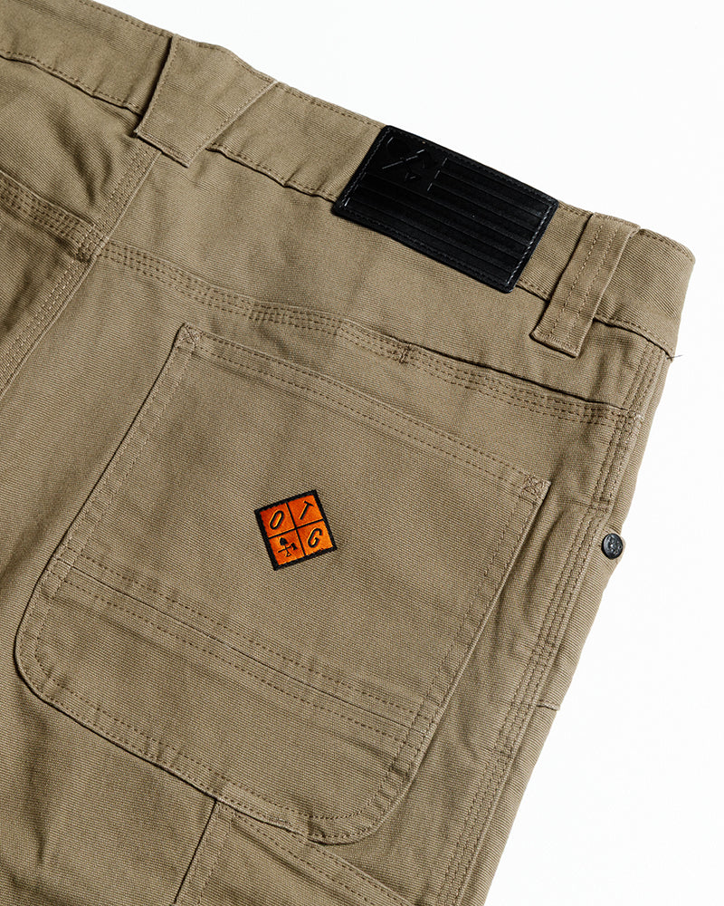 Coyote tan pants with back pocket and orange logo patch