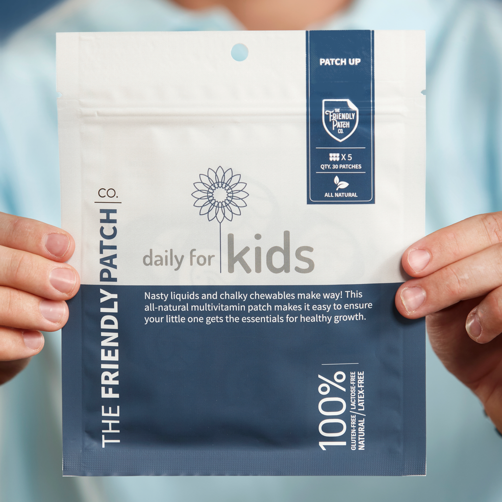 Kids vitamin patch pouch held between fingers, front view with badge and 100% claim