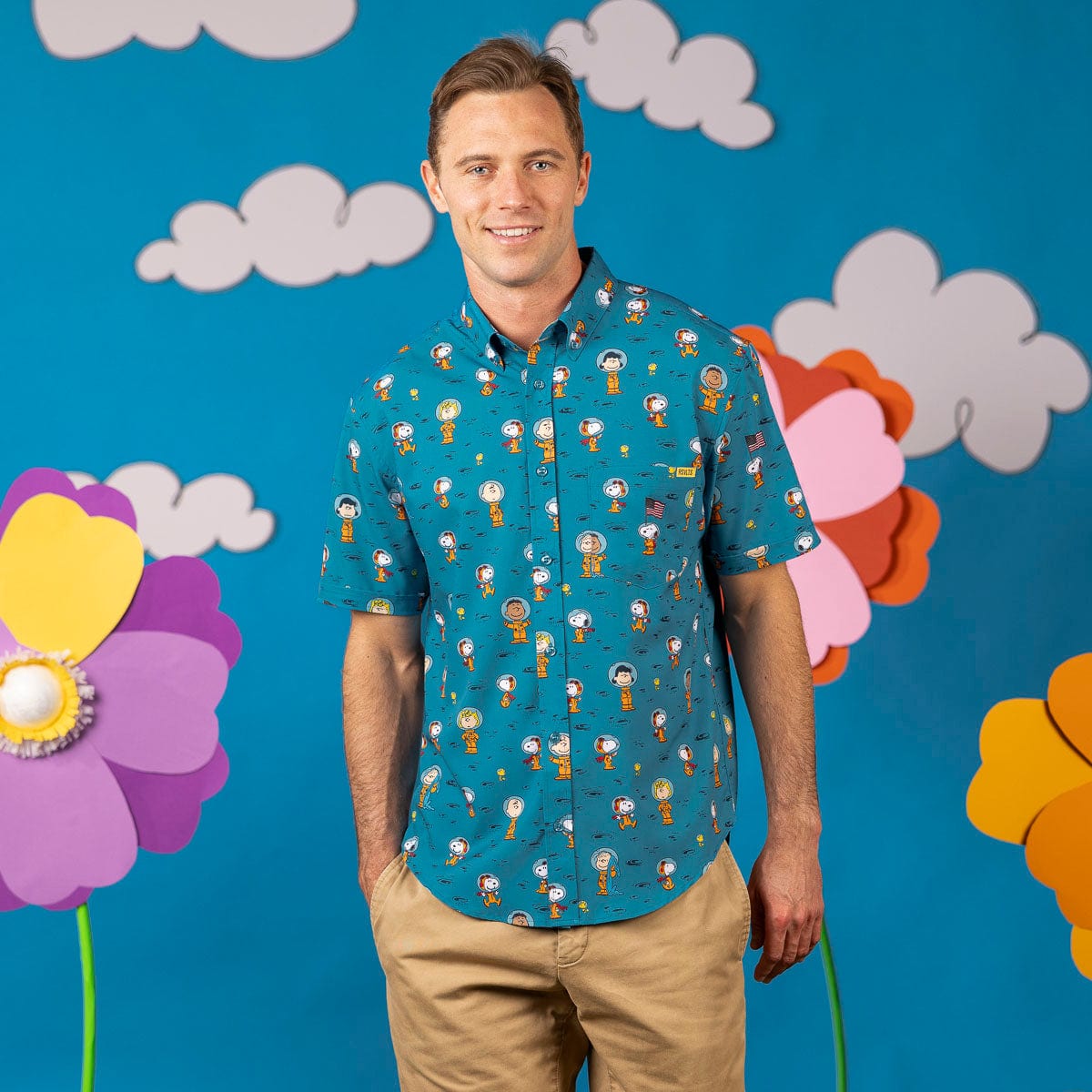 Short-sleeve Peanuts-print button-up shirt in teal, worn by a smiling man