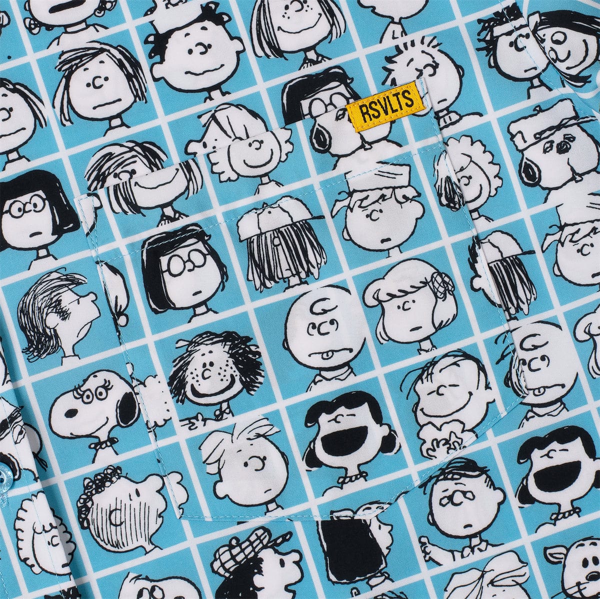 Close-up of blue Peanuts pattern fabric with black-and-white character faces and stripes