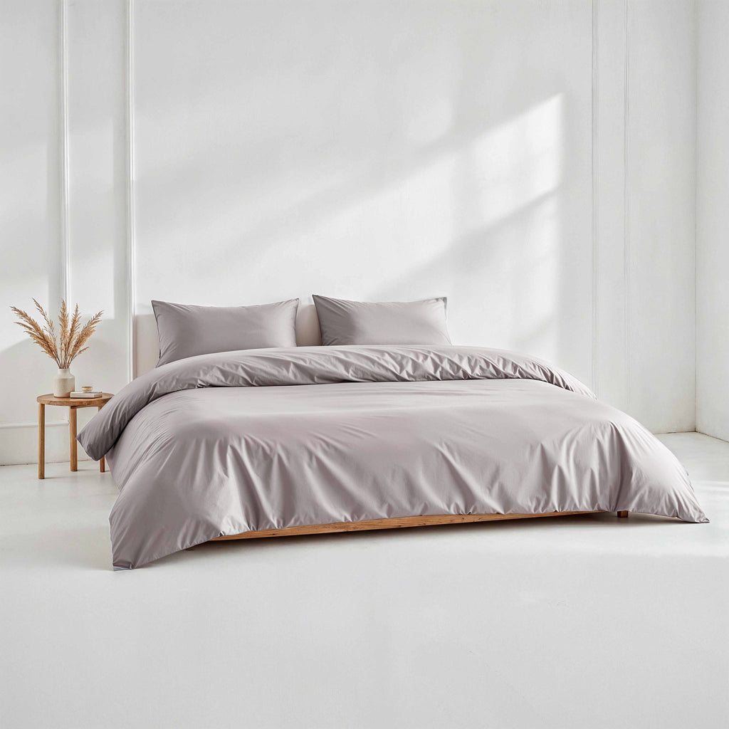 Light gray sateen duvet cover with matching pillow shams on a bed