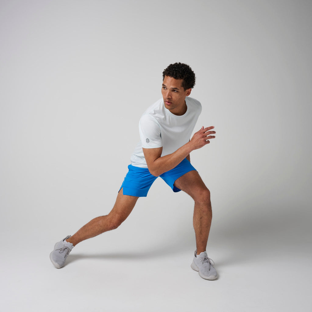 Bright blue shorts with navy waistband and drawstring shown in a running stance