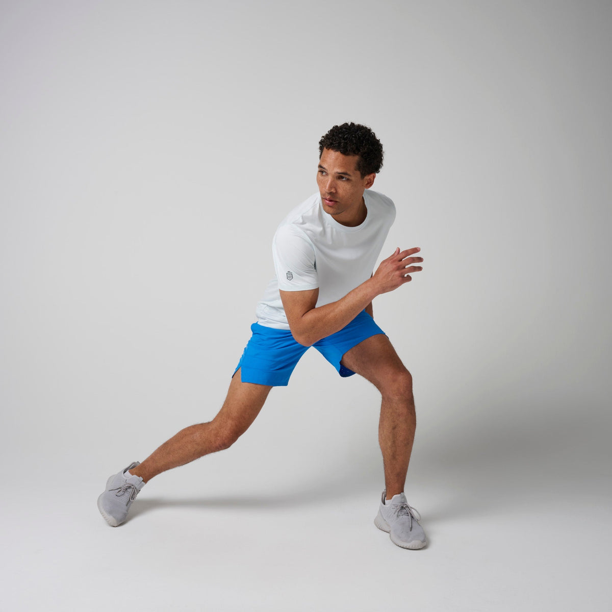 Bright blue shorts with navy waistband and drawstring shown in a running stance