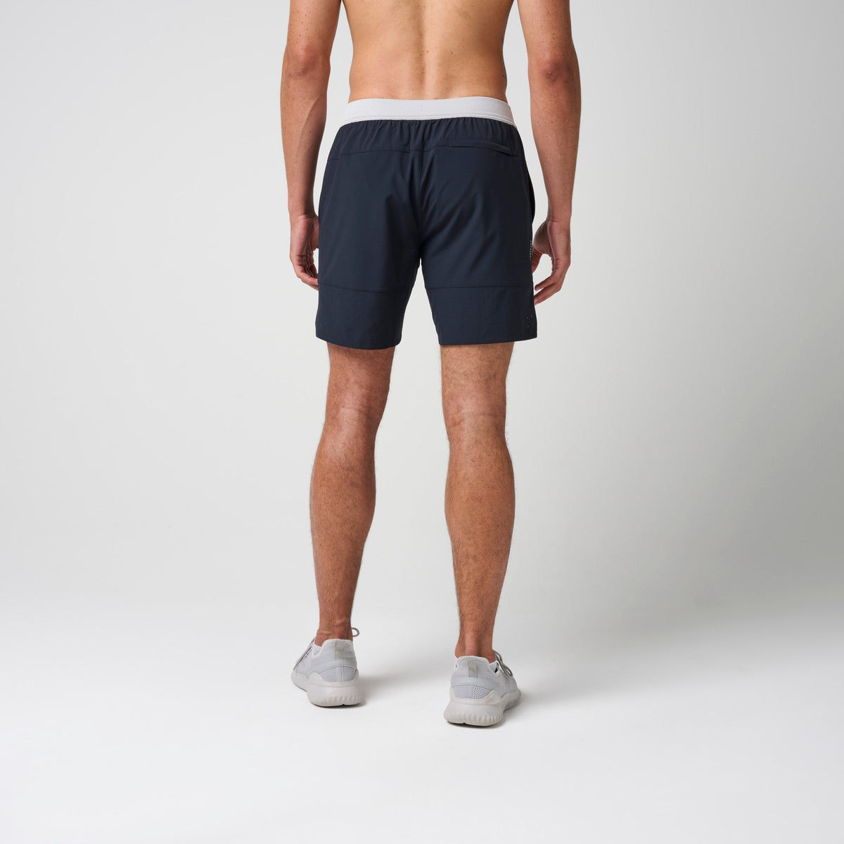 Navy performance training shorts with gray elastic waistband and straight back hem.