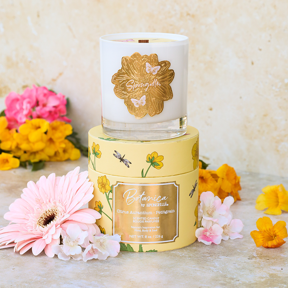 Yellow Botanica candle jar with white wax top and floral logo label
