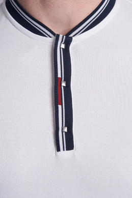White polo placket close-up with navy trim, red stripe, and button