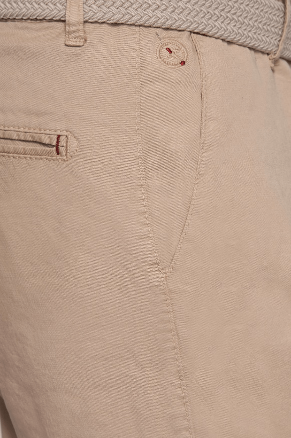 Cream shorts fabric close-up with front button and pocket detail