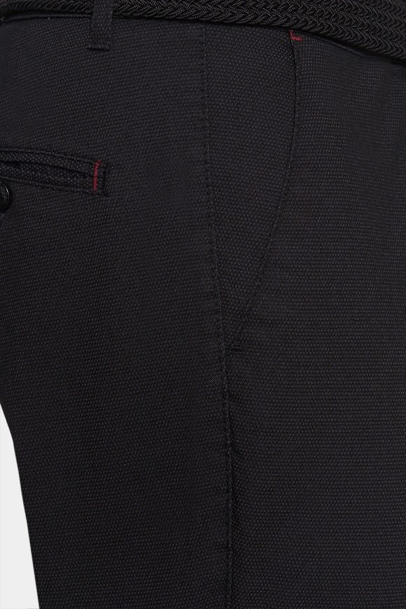 Close-up of black woven shorts with stitched seams and waistband button
