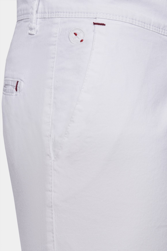 White shorts waistband close-up with red logo embroidery and stitching.