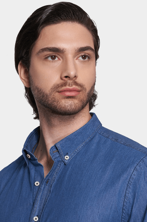 Close-up of blue denim shirt collar with white buttons and stitched button placket
