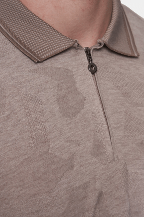 Close-up of quarter-zip polo collar and zipper pull, textured pale beige