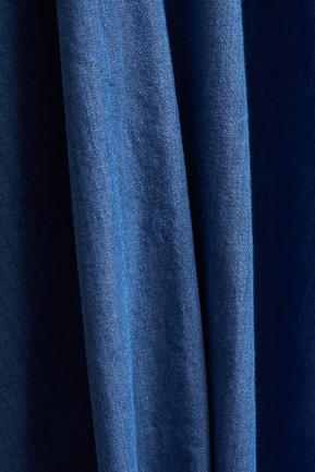 Blue denim fabric close-up showing textured weave and vertical grain