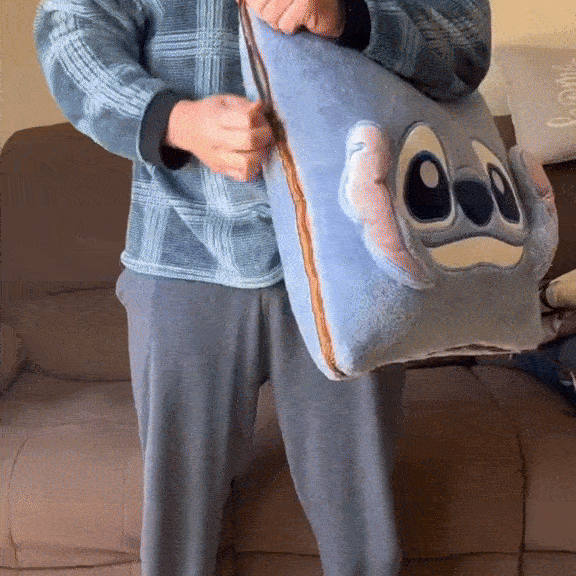 Person holding a blue plush Stitch-style character throw blanket