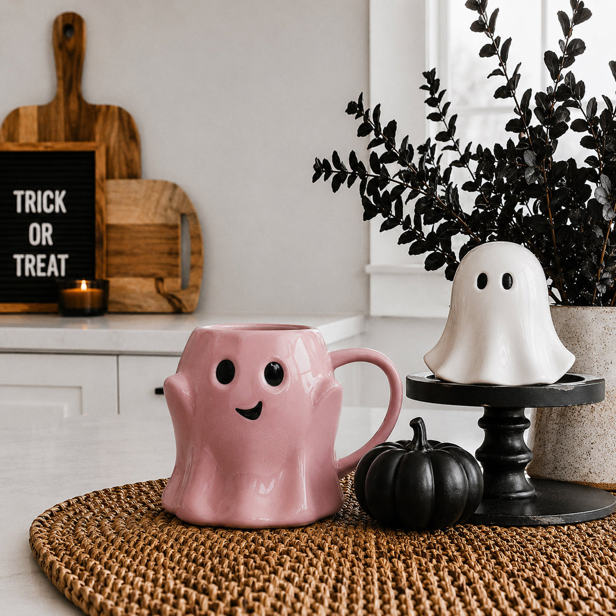 Pink ghost-shaped mug with black eyes and a smiling face