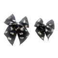 Ghost print hair bow with tied center knot on dark fabric