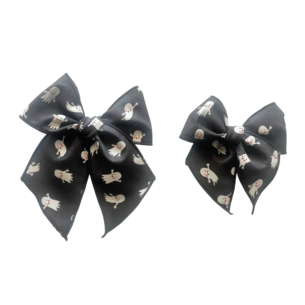Ghost print hair bow with tied center knot on dark fabric