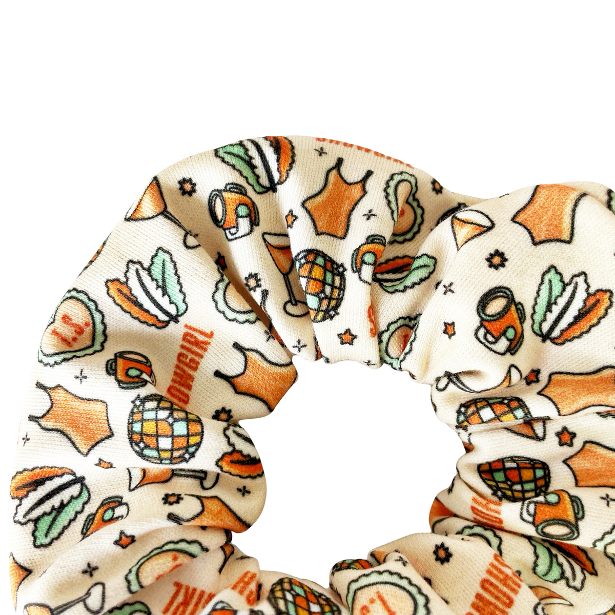 Cream fabric scrunchie with orange and green cartoon motifs
