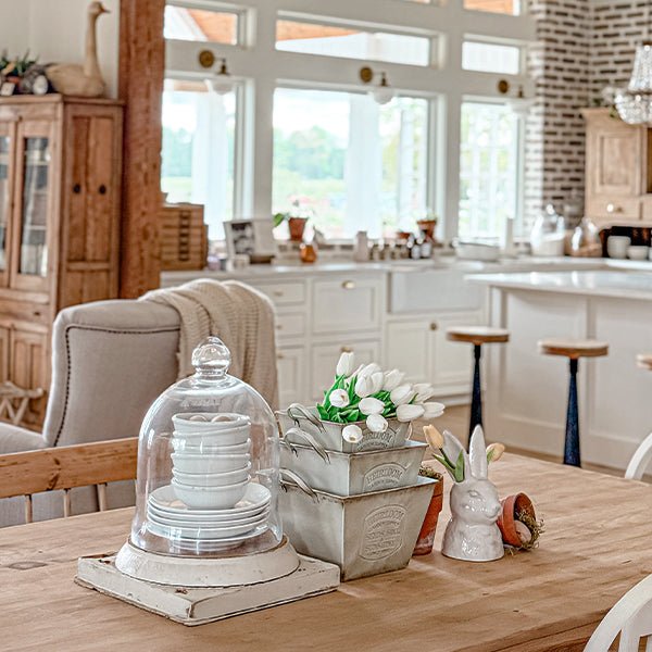 Distressed white metal planter set with handles and embossed text, styled on a dining table.
