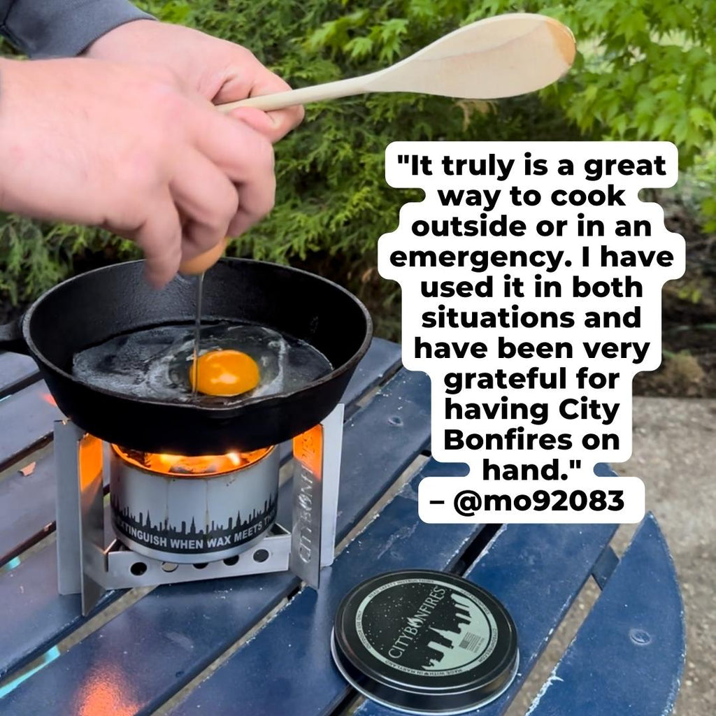 Portable camp stove with skillet and egg over open flame, with fuel canister nearby