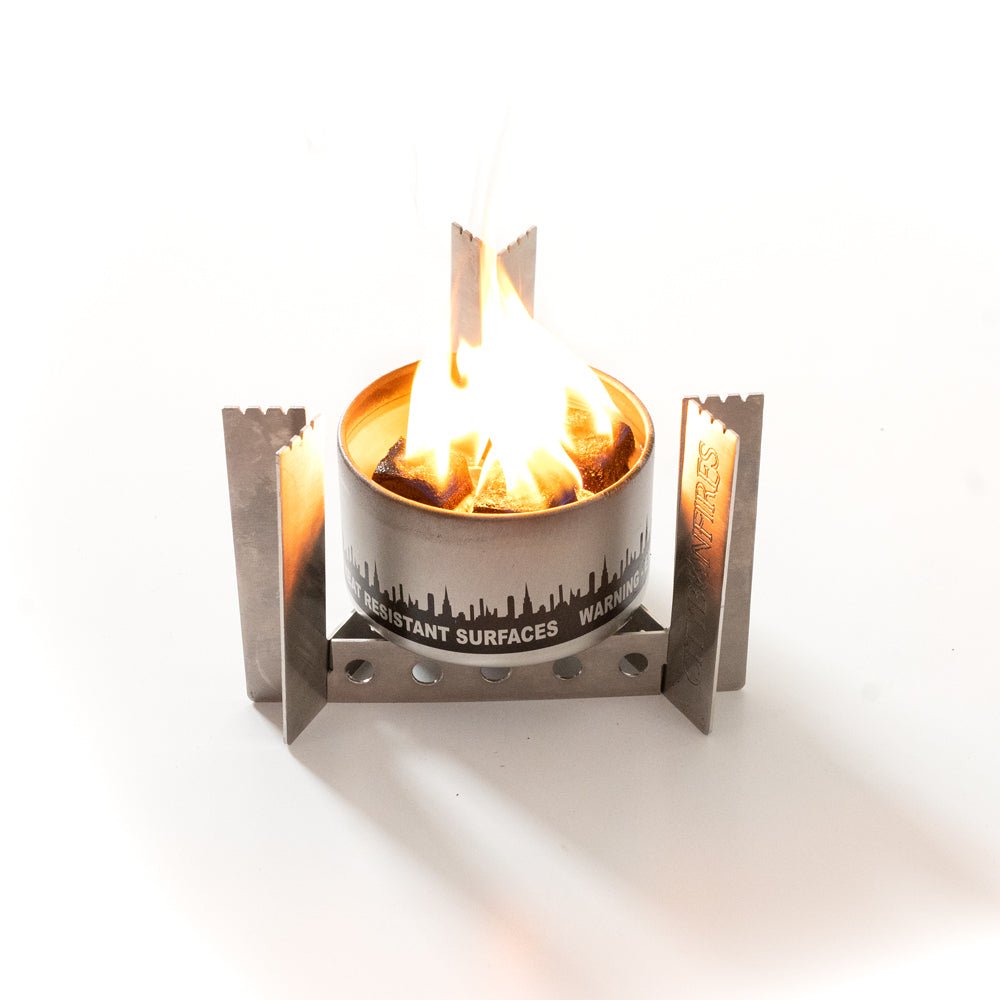 Portable camp stove burner with tall flames under metal frame