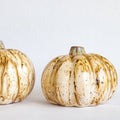 Ceramic pumpkin figurine with beige glaze and speckled vertical ridges, brown stem