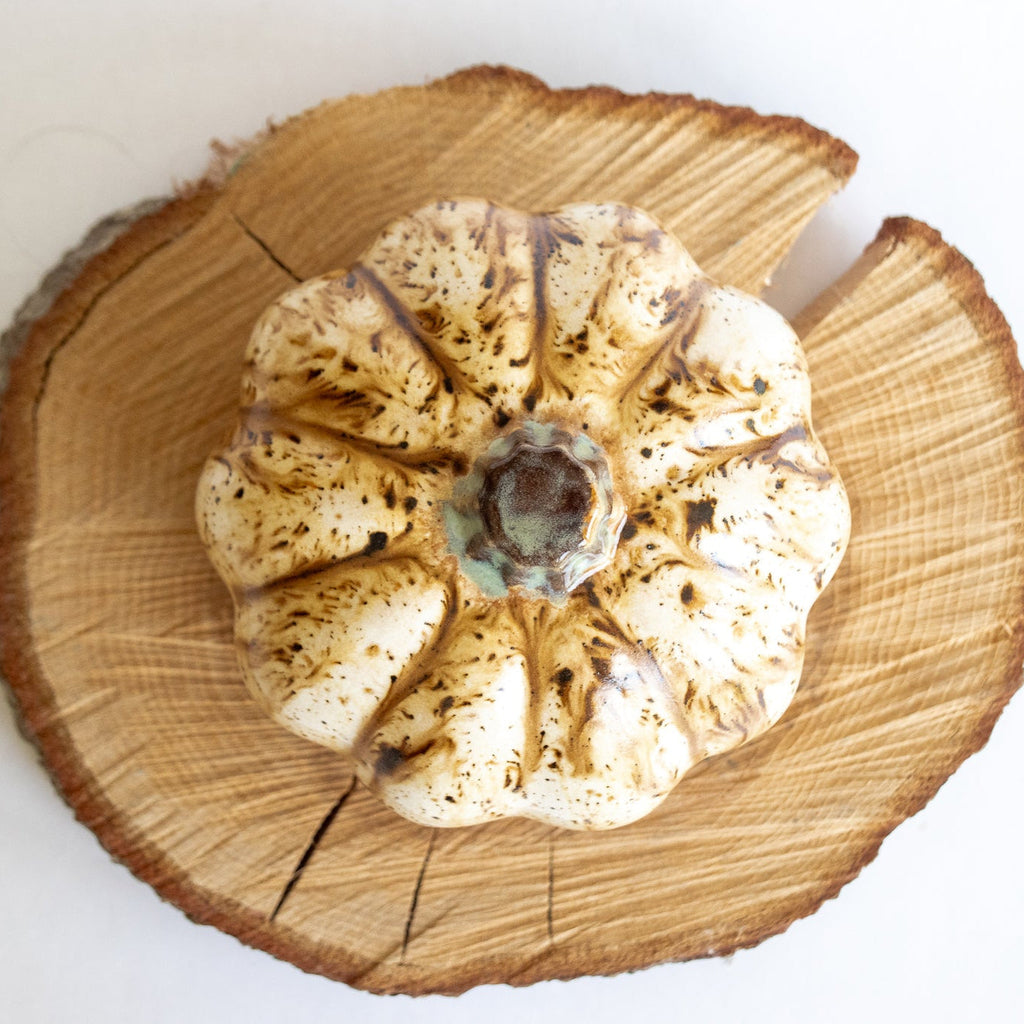 Ceramic pumpkin figurine with beige speckled glaze and silver-toned top opening